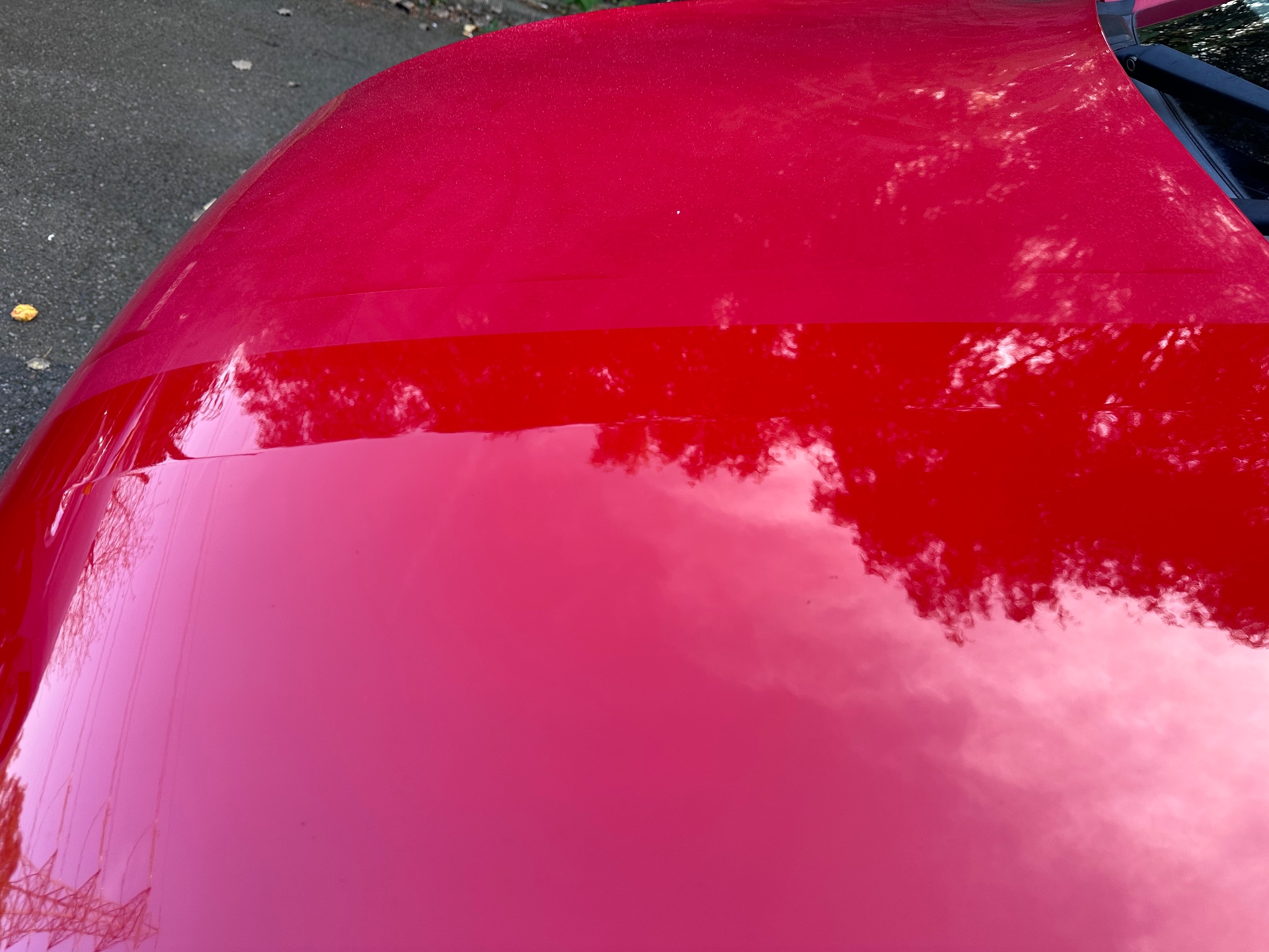 Machine polish result — deep gloss finish on red paintwork